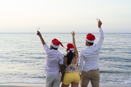 Friends celebrating the New Year's Eve party at the beach. New Year's Eve Celebration Concept