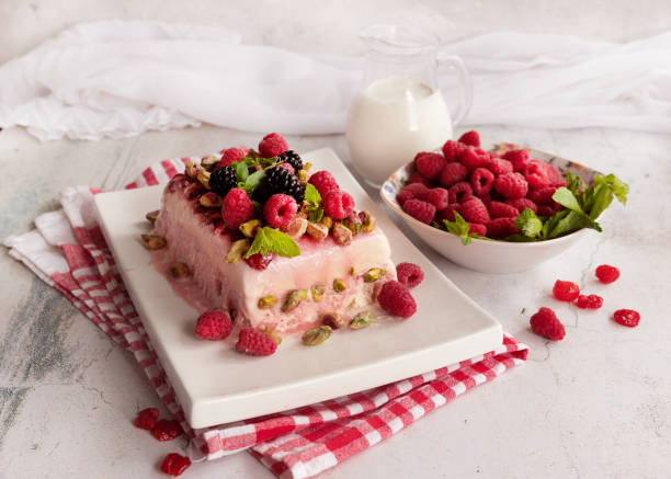 Raspberry ice cream dessert; semifredo decorated with mint on a white plate