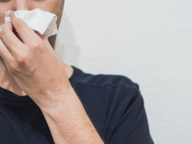 istock Cold man blowing his nose with copy space 1354197574