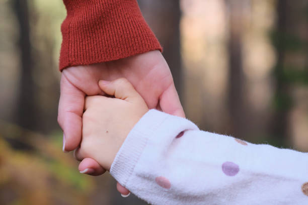 istock Mother and daughter holding hands 1354199007