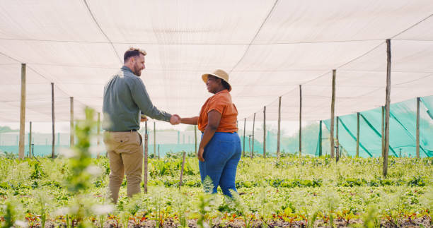 Shot of a farmer welcoming a new team member on board stock photo