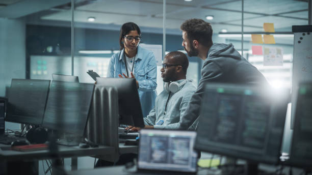 istock Diverse Group of Professionals Meeting in Modern Office: IT Programmers Use Computer, Talk Strategy, Discuss Planning. Specialists Create Innovative Software. Engineers Develop Inspirational App 1354205077