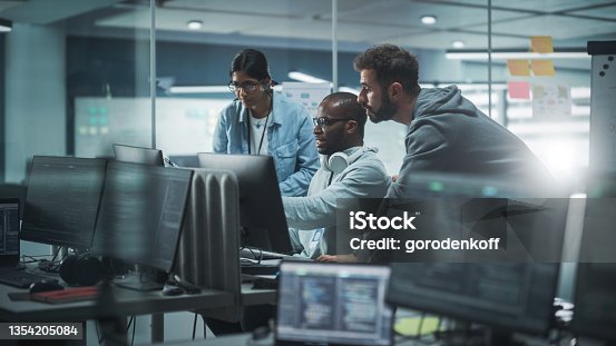 istock Diverse Group of Professionals Meeting in Modern Office: Brainstorming IT Programmers Use Computer Together, Talk Strategy, Discuss Planning. Software Engineers Develop Inspirational App Program 1354205084
