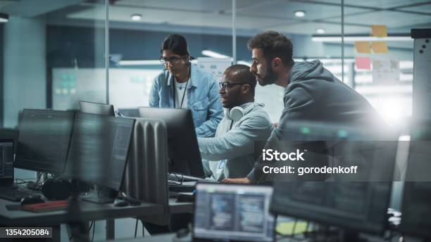 Diverse Group Of Professionals Meeting In Modern Office Brainstorming It Programmers Use Computer Together Talk Strategy Discuss Planning Software Engineers Develop Inspirational App Program Stock Photo - Download Image Now