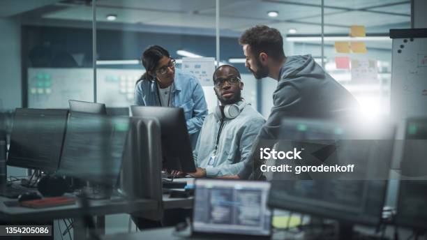 Diverse Group Of Professionals Meeting In Modern Office Brainstorming It Programmers Use Computer Together Talk Strategy Discuss Planning Software Engineers Develop Inspirational App Program Stock Photo - Download Image Now