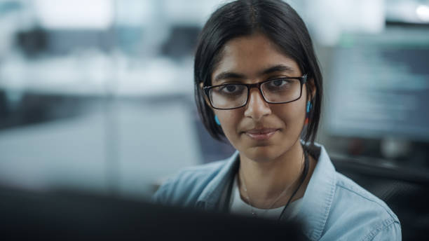 istock Diverse Office: Portrait of Empowered Indian IT Programmer Working on Desktop Computer. Female Specialist Wearing Glasses Create Innovative Software. Professional Engineer Develop Inspirational App 1354205197