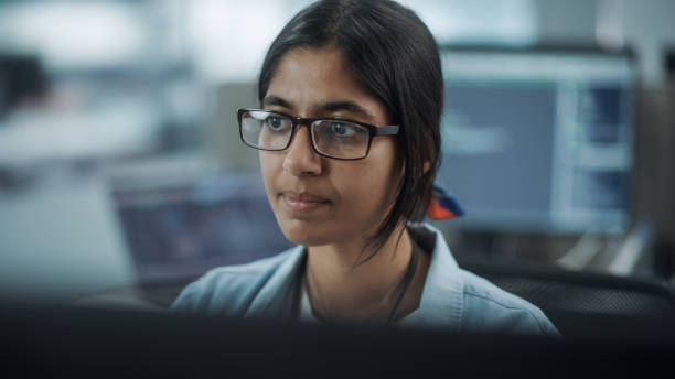 istock Diverse Office: Portrait of Confident Indian IT Programmer Working on Desktop Computer. Female Specialist Wearing Glasses Create Innovative Software. Professional Engineer Develop Inspirational App 1354205209