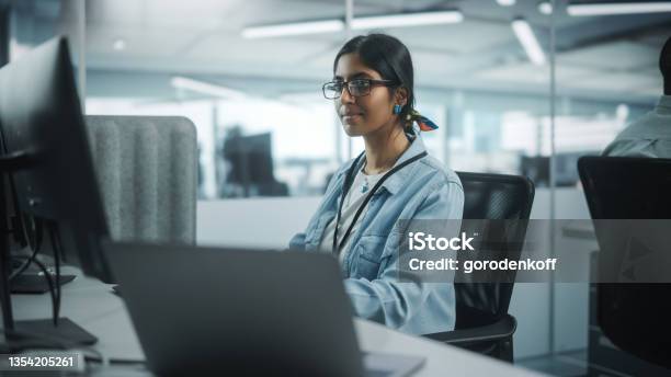 Diverse Office Portrait Of Talented Indian Girl It Programmer Working On Desktop Computer In Friendly Multiethnic Environment Female Software Engineer Wearing Glasses Develop Inspirational App Stock Photo - Download Image Now