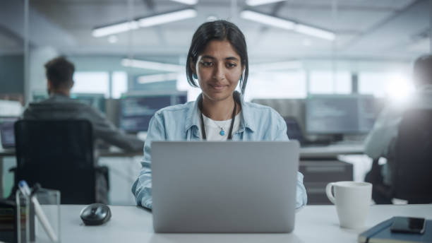 istock Diverse Office: Portrait of Beautiful Indian IT Programmer Working on Desktop Computer, Smiling. Female Software Engineer Creating Innovative App, Program, Video Game 1354205457
