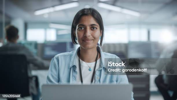 Diverse Office Portrait Of Beautiful Indian It Programmer Working On Desktop Computer Smiling And Looking At Camera Kindly Female Software Engineer Creating Innovative App Program Video Game Stock Photo - Download Image Now