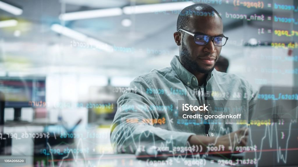 Modern Office: Portrait of Motivated Black IT Programmer Working on Laptop Computer. Male Specialist Create Website, Software Engineer Develop Programme. Shot with Visual Effects of Running Code. Network Security Stock Photo