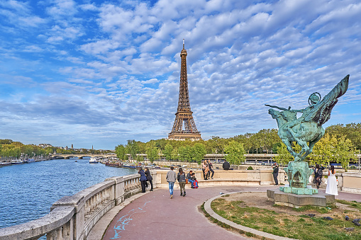 Paris, France - Seeptember 30, 2021: Pedestrians on the Seine river promenade in front of the Eiffel Tower.