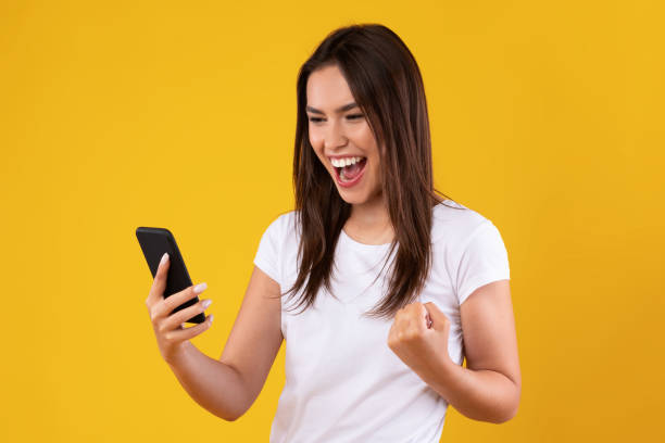 istock Happy excited lady using mobile phone at studio, saying yes 1354207799