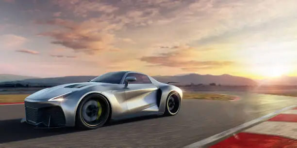Side view of a generic silver sports car moving at high speed close to the camera. The roadster is driving on a racetrack at high speed causing motion blur in the foreground. The action takes place at dawn. With selective focus on the foreground.