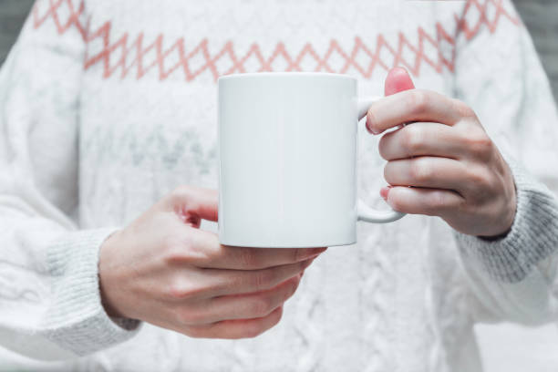 istock Woman's hands holding white coffee or tea cup, mockup. 1354209711