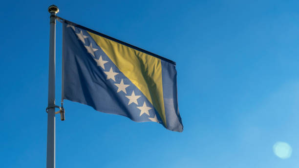 Bosnia Herzegovina national flag waving in the wind on a deep blue sky. Diplomacy and international relations concept. Bosnia Herzegovina national flag waving in the wind on a deep blue sky. Diplomacy and international relations concept. Space for text. bosnia and herzegovina stock pictures, royalty-free photos & images