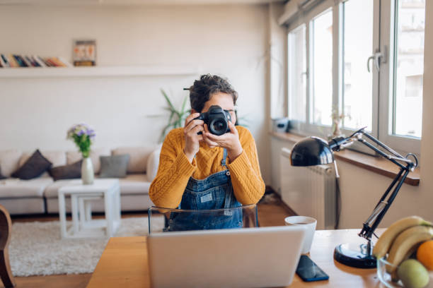 istock Young photographer making photos at her home office 1354212136