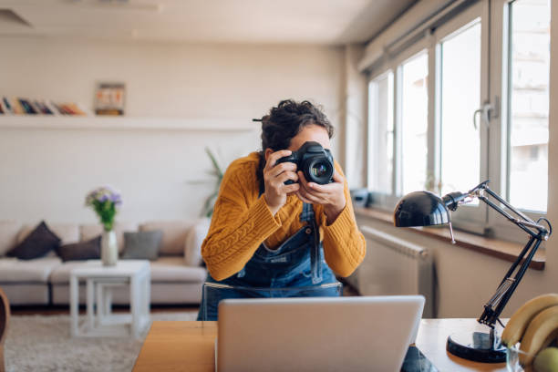 istock Young photographer making photos at her home office 1354212138