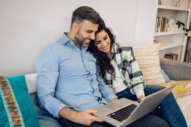 istock Couple relaxing on the sofa and using laptop 1354212403