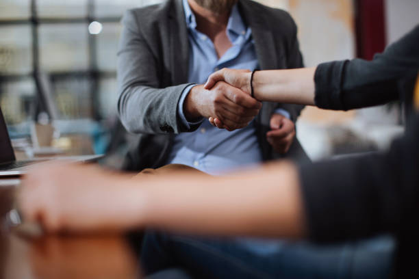 Mortgage broker shaking hands with clients