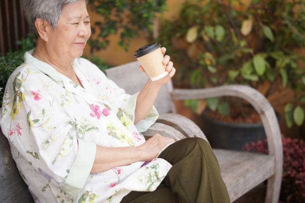 istock old elderly senior elder woman drinking hot coffee in garden 1354213529