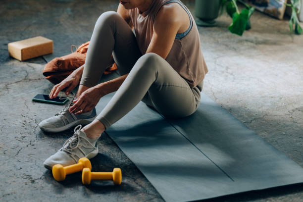istock An Anonymous Woman Tying Laces on her Sneakers Before Home Workout 1354213775