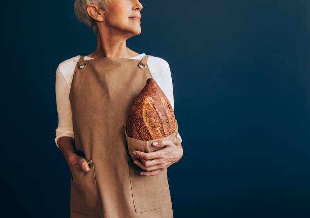 istock Unrecognizable Woman in Apron Holding Freshly Made Bread 1354214139