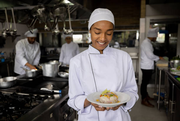 istock Cook working in a commercial kitchen and presenting a plate 1354214233