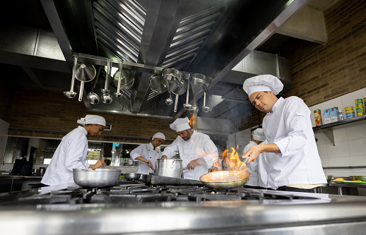 Group of Latin American chefs cooking in the kitchen of a restaurant - food service concepts