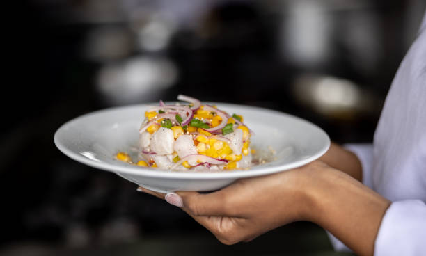 istock Close-up on a chef holding a plate of ceviche at a restaurant 1354214271