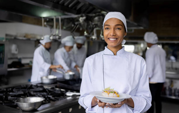 istock Happy cook preparing food at a restaurant and presenting a plate 1354214272