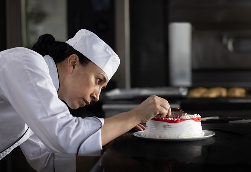 Latin American female chef decorating a dessert at a restaurant - fine dining concepts