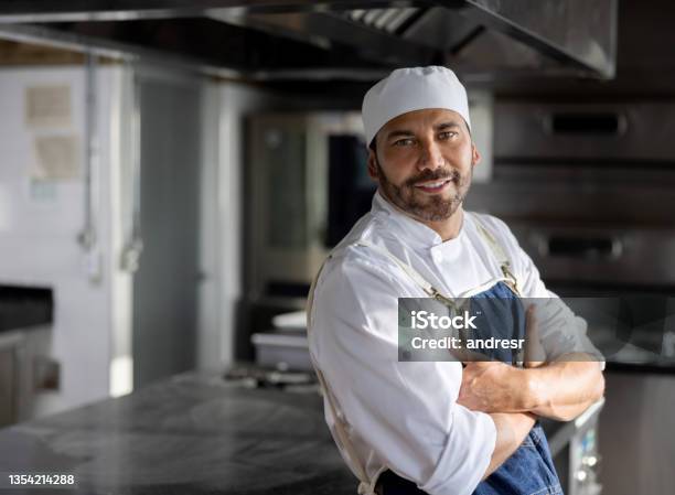 Happy Cook Working In The Kitchen Of A Restaurant And Smiling Stock Photo - Download Image Now