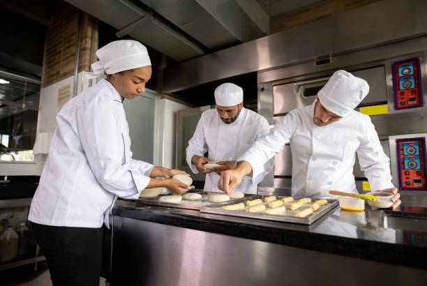 istock Team of bakers working at a bakery making bread 1354214324
