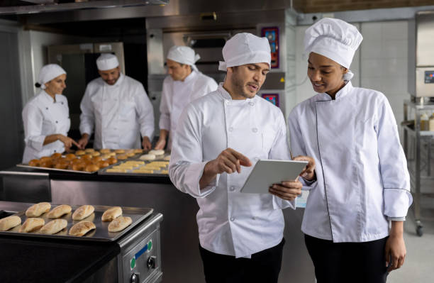 istock Bakers at the bakery looking for new recipes on a tablet 1354214336