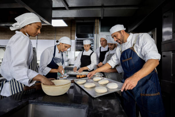 istock Group of bakers working at the bakery making bread 1354214337