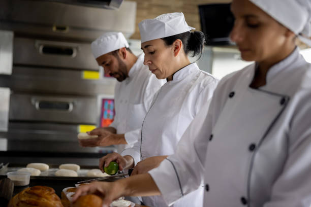 istock Head chef working with her apprentices at the baking pastries 1354214342