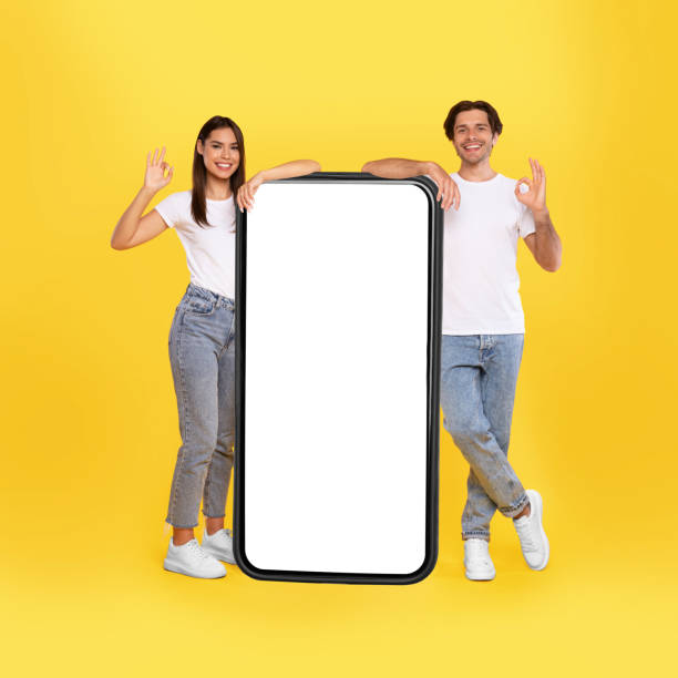 istock Couple showing white empty smartphone screen and gesturing ok 1354215586