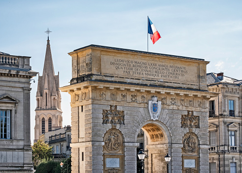View of the triumphal arch and local architecture and a church in the public park Jardin de Peyrou in Montpellier, France.