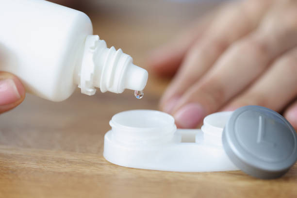 istock Female hand pouring lens liquid into plastic container closeup 1354217100