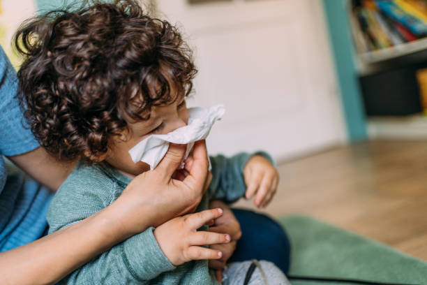 istock Mother helping son to blow his nose. 1354217832
