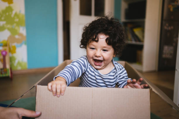 Little boy playing in cardboard box during relocation.