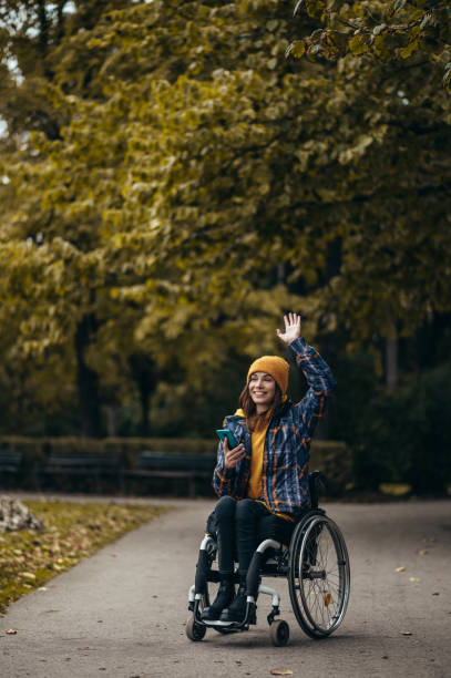 istock Woman with disability using a smartphone while out in the city park 1354218040