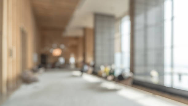 Blurred hotel or office building lobby blur background interior view toward reception hall, modern luxury white room space with blurry corridor and building glass wall window Blurred hotel or office building lobby blur background interior view toward reception hall, modern luxury white room space with blurry corridor and building glass wall window school receptionist stock pictures, royalty-free photos & images