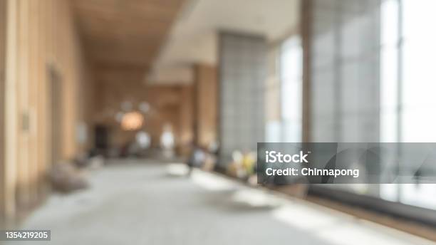 Blurred Hotel Or Office Building Lobby Blur Background Interior View Toward Reception Hall Modern Luxury White Room Space With Blurry Corridor And Building Glass Wall Window Stock Photo - Download Image Now