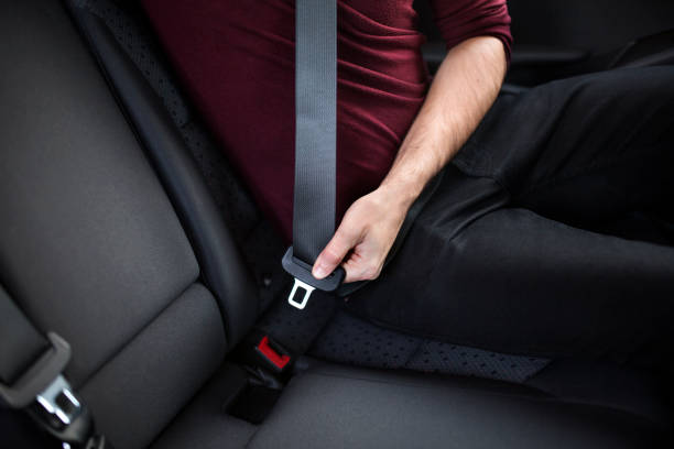 istock Young man in a car, fastening a seatbelt 1354219549