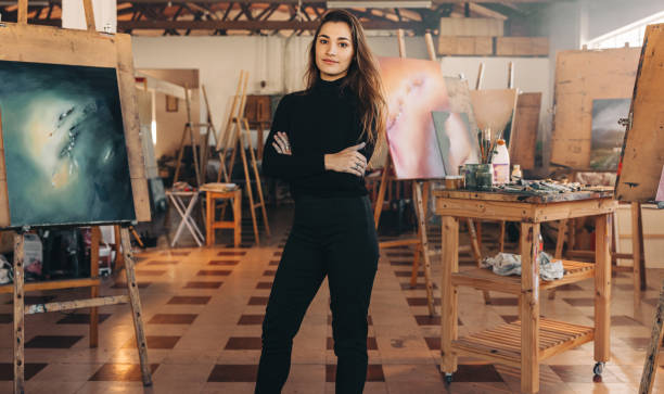 istock Professional painter standing in her atelier with her arms crossed 1354219972