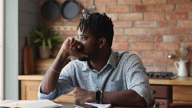 African man holds smartphone reading message feels stressed looks upset