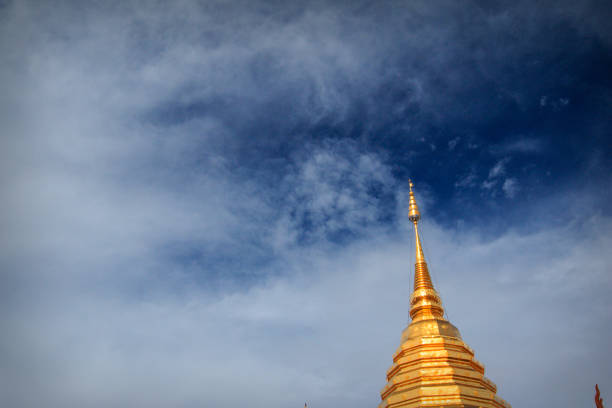 Golden pagoda peak over blue sky in Chiang Mai, Thailand