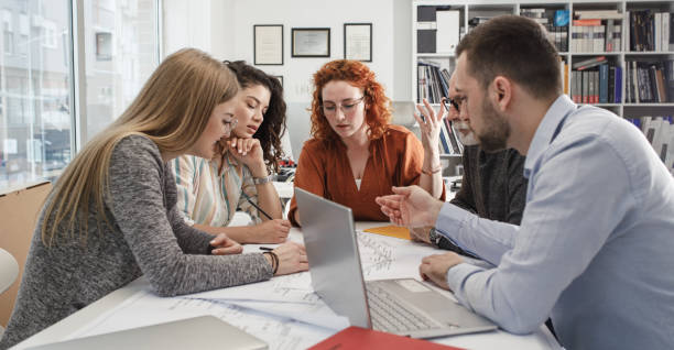 istock Working day in a design studio.Group of designers on meeting.Thay discuss about new project. 1354222806
